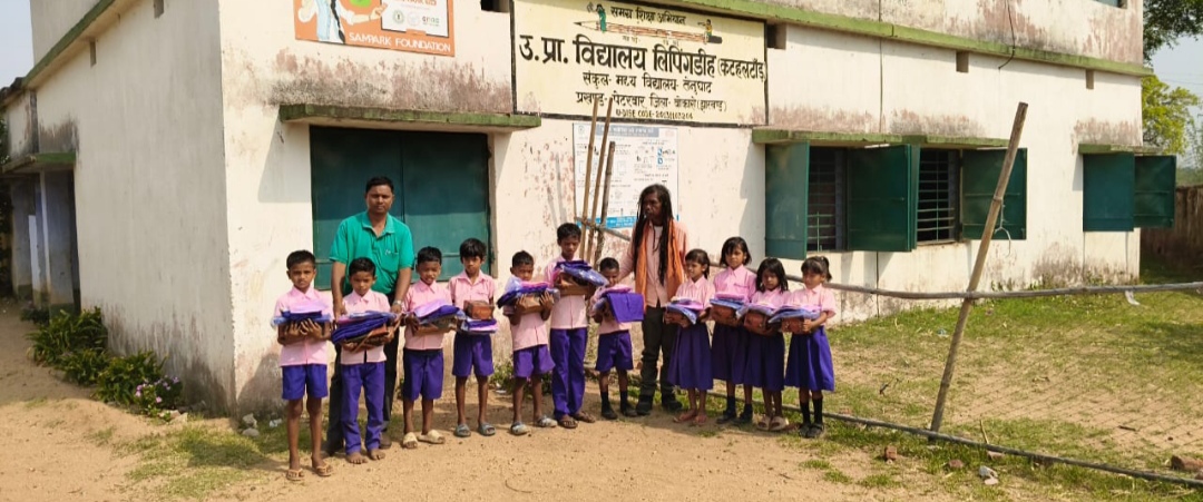 उत्क्रमित प्राथमिक विद्यालय में पहली और दूसरी कक्षा के छात्रों के बीच पोशाक वितरण।